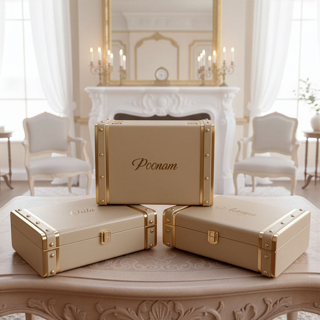 Three beige trunk boxes with gold accents on a table in a elegant room by TPC Gifts