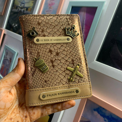 Personalized passport cover from TPC Gifts which is a Personalized Passport Cover in golden colour, personalised with name and 4 charms and 1 quotes in a flat lay view.