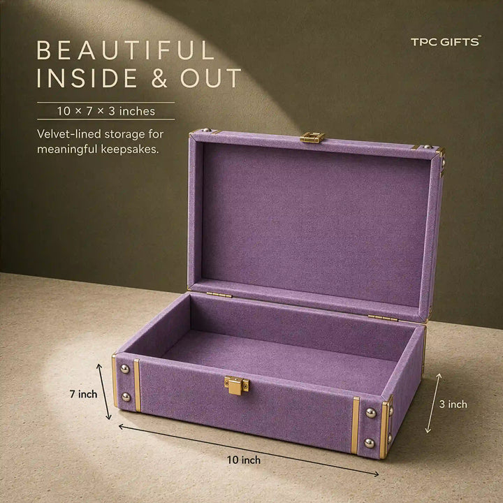 An open purple velvet-lined storage box with gold-tone metal corner accents and a small front clasp, shown on a beige surface against a dark olive background. White text on the left reads &