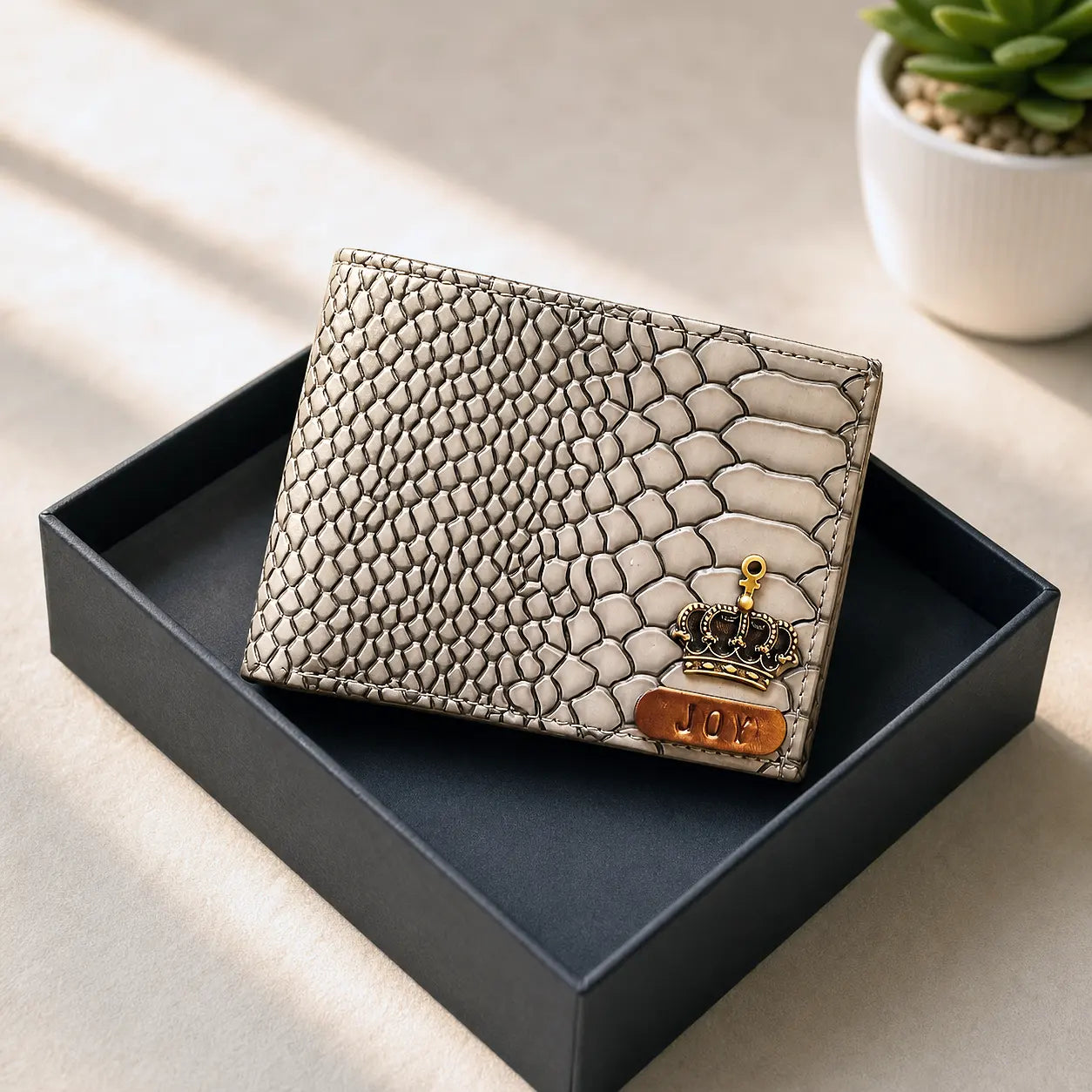 snake-patterned wallet with a crown emblem on a black tray by tpc gifts personalized wallet for men