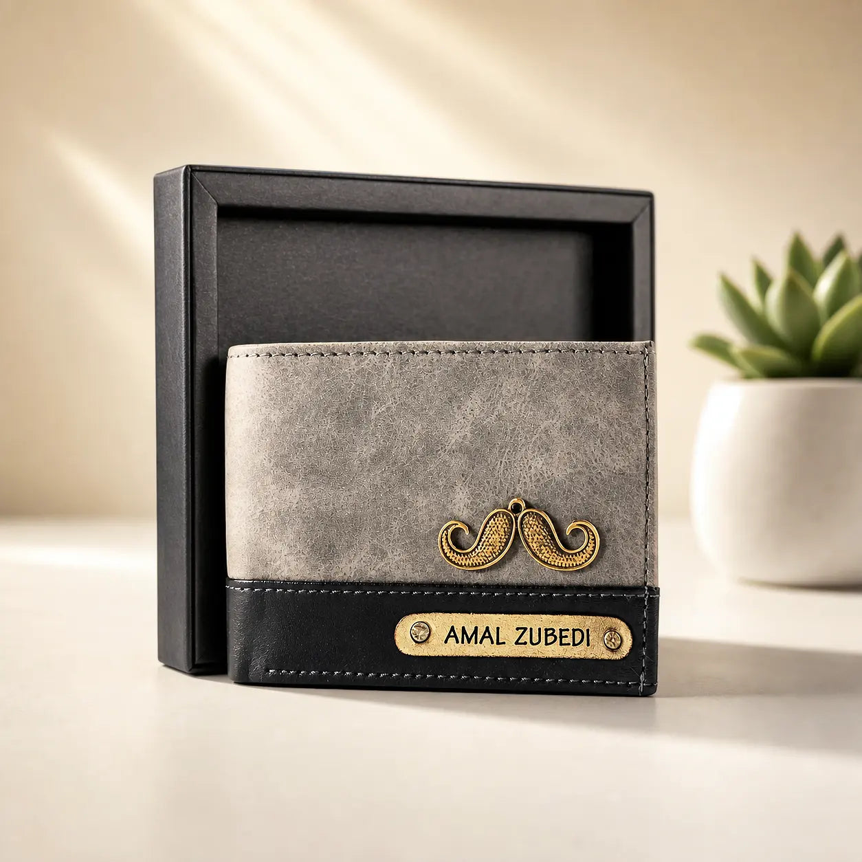 Gray wallet with gold mustache design and 'AMAL ZUBEDI' name in a black box on a light surface by tpc gifts personalized wallet for men