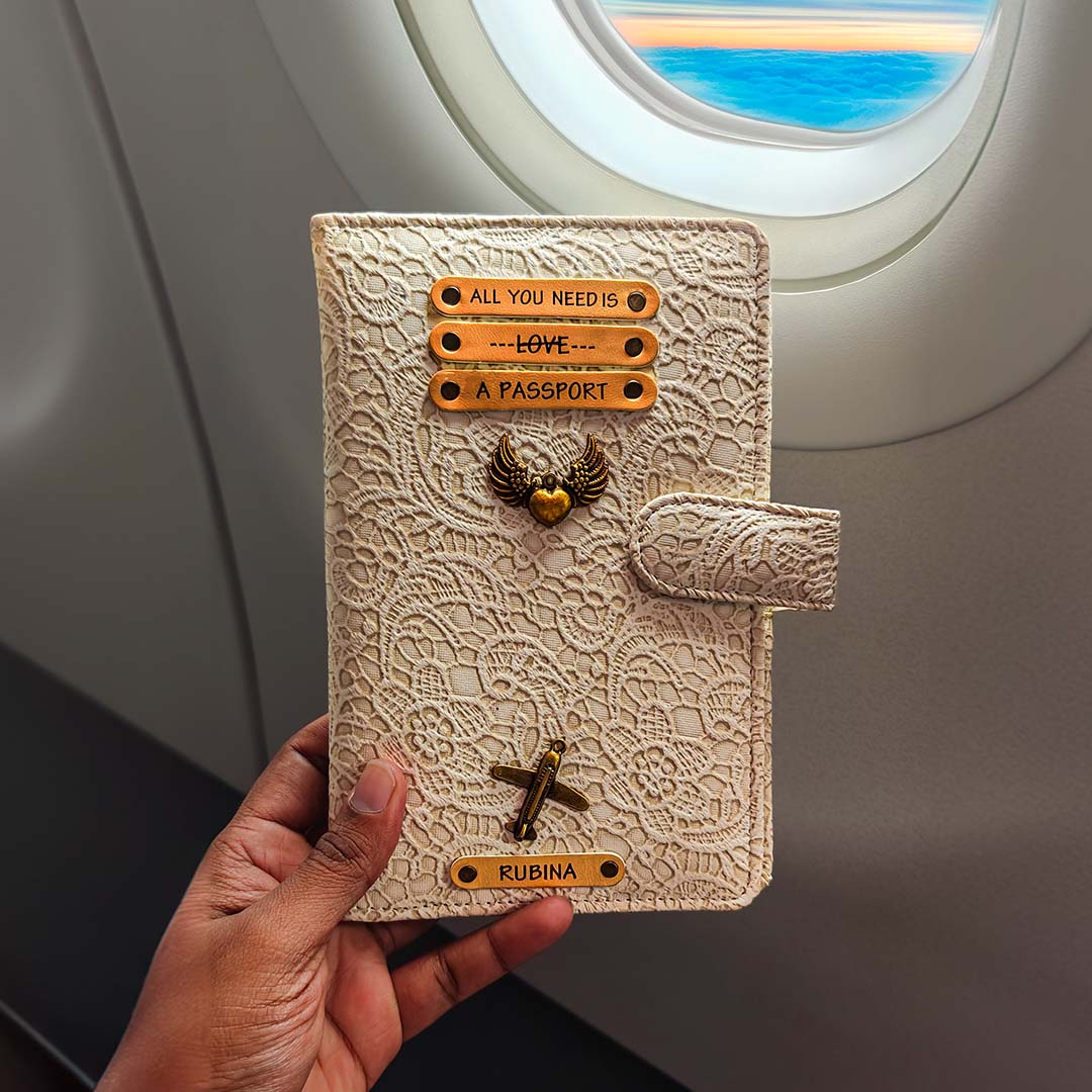 Hand holding a decorative passport holder with airplane window in the background