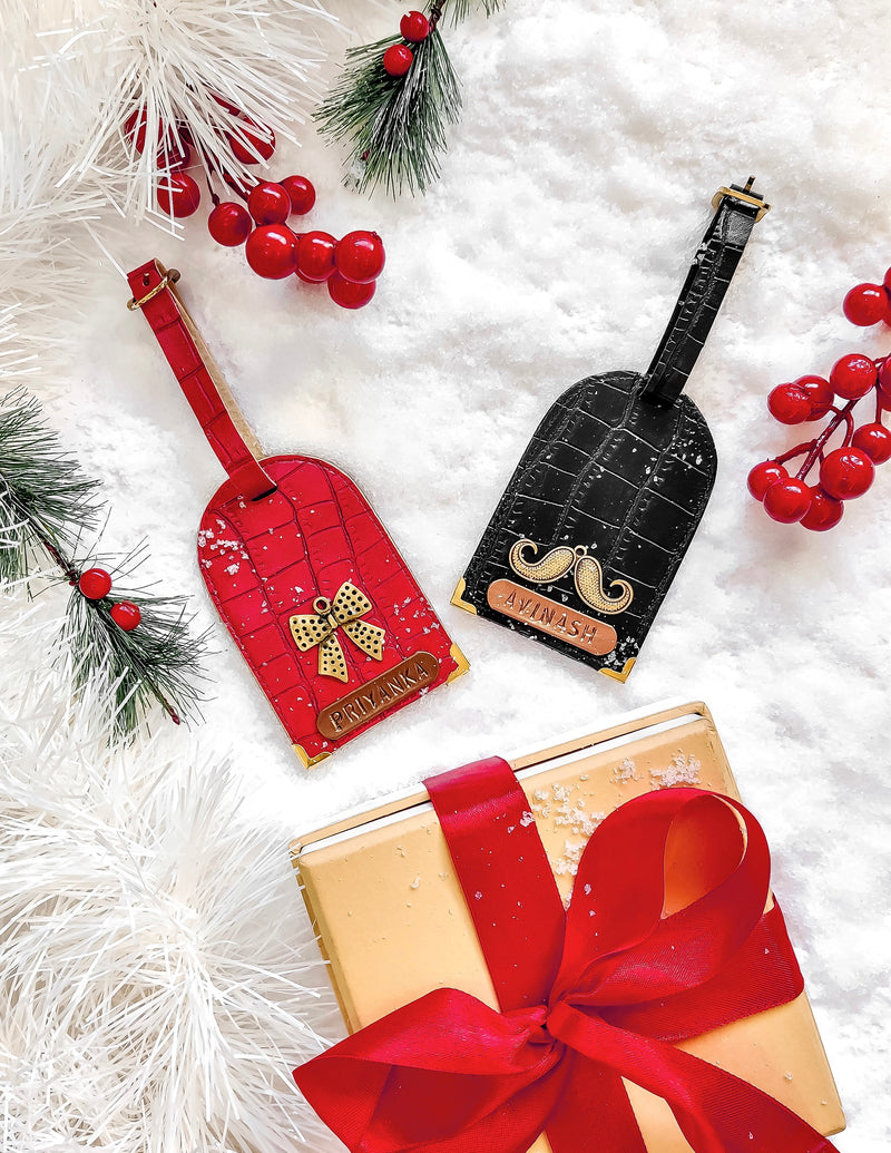 Cheery red and Black Couple Luggage Tag by TPC Gifts. on Snow with gift box at the side. 