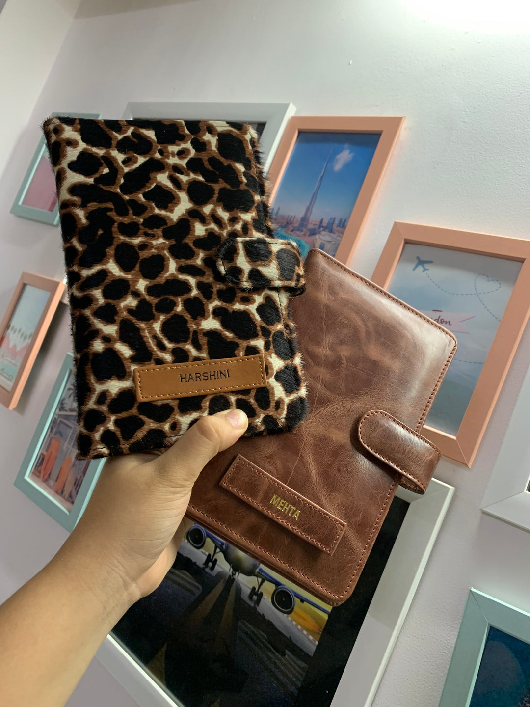Two travel organizers, one with a solid brown color and another with a animal print, placed on a surface with a cup of coffee and a book at backgroud setup from TPC Gifts